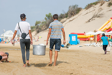 Image showing Two men selling corn on the beach