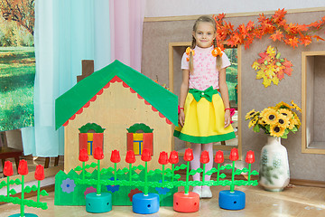 Image showing  A girl stands at the scenery house on matinee in kindergarten