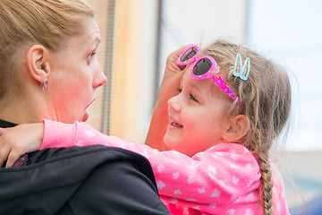 Image showing Young mother amuses his three-year daughter