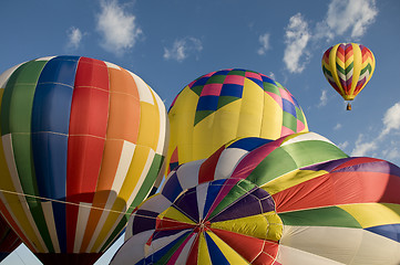 Image showing Hot-air balloons inflating with another balloon already aloft