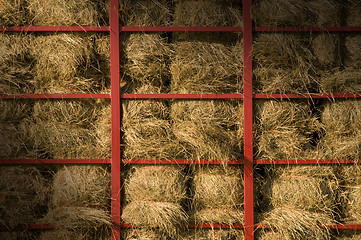 Image showing Hay bales piled within a cart lit diagonally