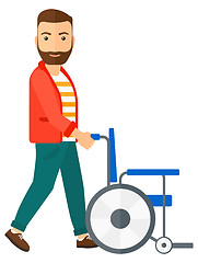 Image showing Man pushing wheelchair.