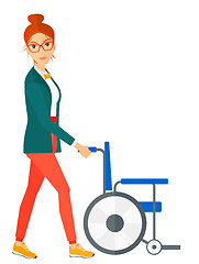 Image showing Woman pushing wheelchair.