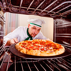 Image showing Chef cooking pizza in the oven.