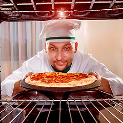 Image showing Chef cooking pizza in the oven.