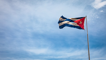 Image showing Cuban flag flying in the wind on a backdrop of blue sky.