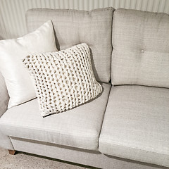 Image showing Gray sofa with knitted cushion