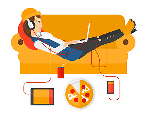 Image showing Woman with gadgets lying on sofa.