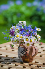 Image showing A bouquet of wildflowers in a circle on the table  