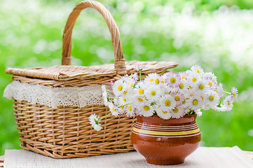 Image showing A bouquet of daisies in a pot on the table for a picnic