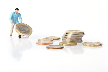 Image showing Miniature worker drives euro coins