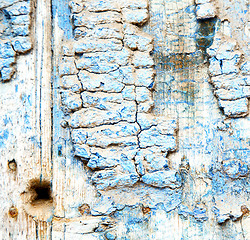 Image showing metal nail dirty stripped paint in the brown wood door and rusty