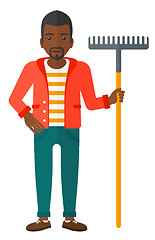 Image showing Man standing with rake.