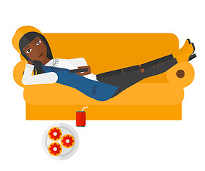 Image showing Woman lying on sofa with junk food.