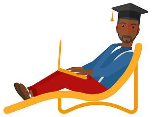 Image showing Graduate lying on chaise lounge with laptop.