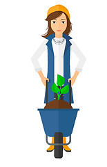 Image showing Woman with plant and wheelbarrow.