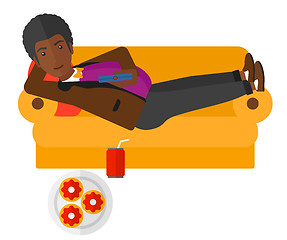 Image showing Man lying on sofa with junk food.