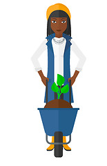 Image showing Woman with plant and wheelbarrow.