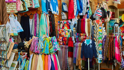 Image showing Rows of colourful silk scarfs hanging at a market stall