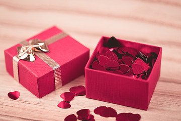 Image showing Red hearts confetti on wooden background