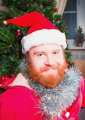 Image showing A bearded man in a red suit of Santa Claus smiling