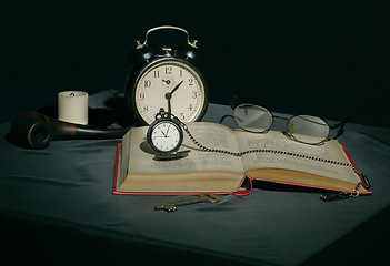 Image showing Still life with a book and clocks in dark colors