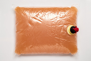 Image showing Plastic bag with tap full of apple juice 