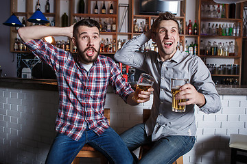 Image showing Young people with beer watching football in a bar