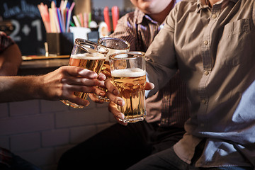 Image showing Happy friends drinking beer at counter in pub