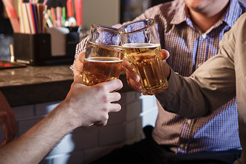 Image showing Happy friends drinking beer at counter in pub