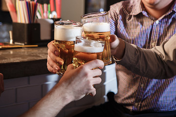 Image showing Happy friends drinking beer at counter in pub