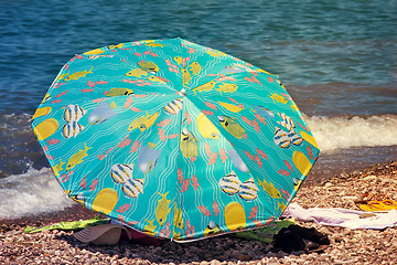 Image showing Sunshades and clothes on a sea beach  