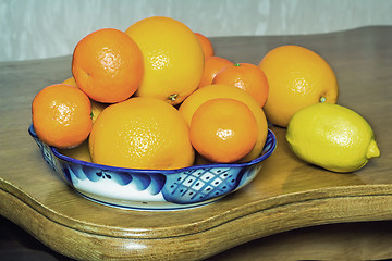 Image showing Oranges and tangerines in a beautiful ceramic vase.