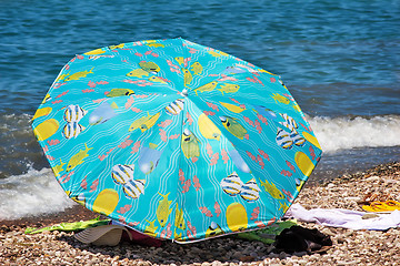 Image showing Sunshades and clothes on a sea beach  