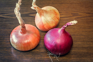 Image showing Still life: three large onions on the table.