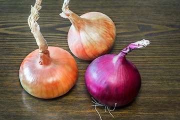 Image showing Still life: three large onions on the table.