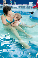 Image showing Mother talks little daughter something in water