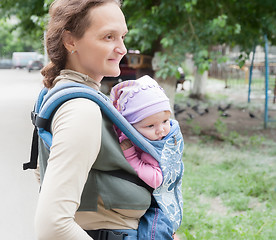 Image showing The young woman with the child on sling