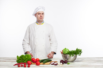 Image showing Chef cutting a green cucumber in his kitchen