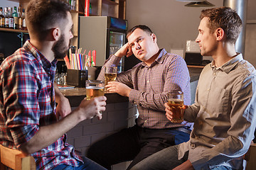 Image showing The  friends drinking beer at counter in pub