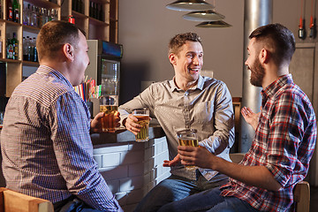 Image showing Happy friends drinking beer at counter in pub