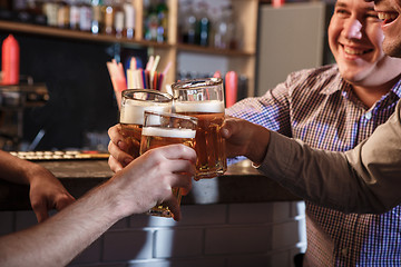 Image showing Happy friends drinking beer at counter in pub