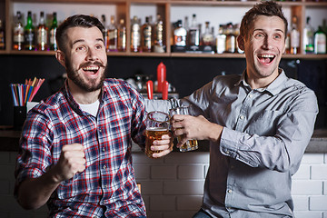 Image showing Young people with beer watching football in a bar