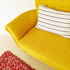 Image showing Yellow sofa with striped cushion