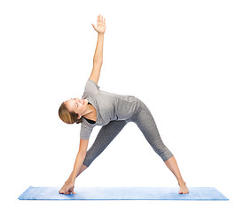 Image showing woman making yoga triangle pose on mat