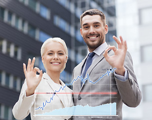 Image showing smiling businessmen standing over office building