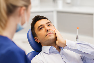 Image showing female dentist and male patient with toothache