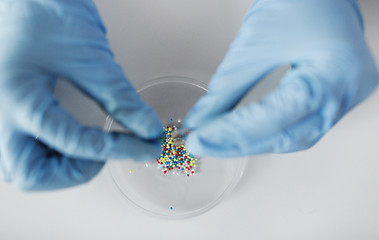 Image showing close up of scientist hands holding pill in lab