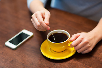 Image showing close up of woman with smartphone and coffee