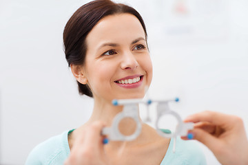 Image showing happy woman having vision test at eye clinic